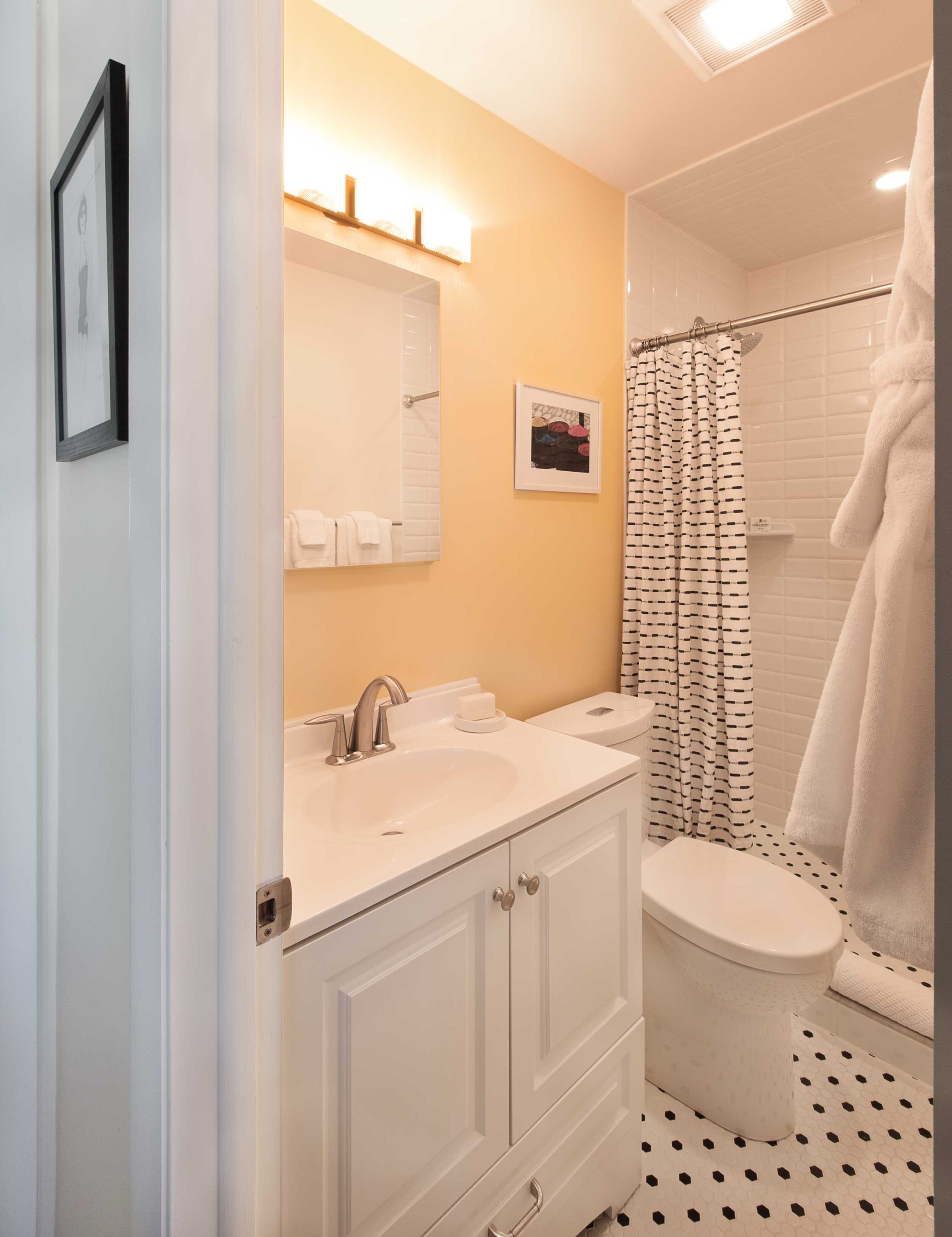 A well stocked black and white bathroom offers organic bath products and organic towels.