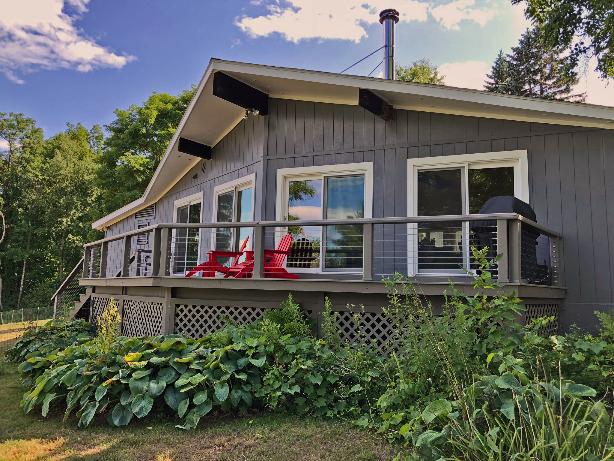 Mid-Century modern home with a relaxing deck, designer-appointed furnishings, 7 private acres of lawns, and 200 feet of private beach.